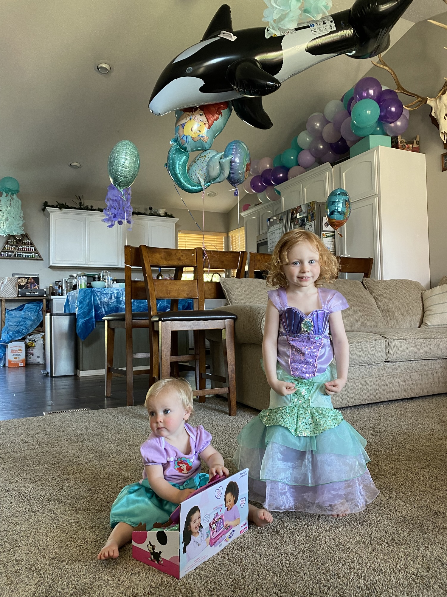 DIY under the sea birthday party decorations transforming a family living room into an underwater celebration with blue streamers and ocean-themed decor.