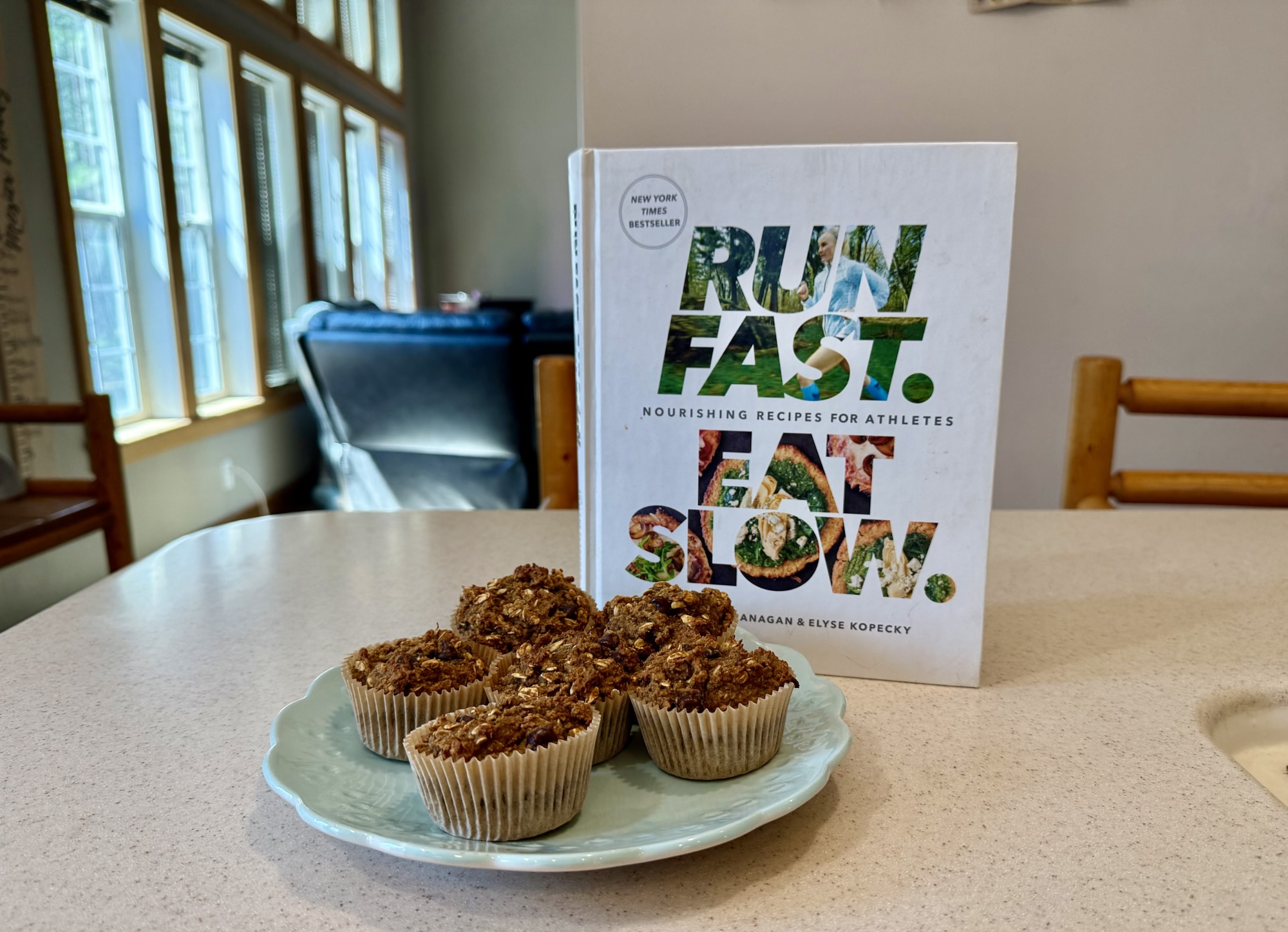 Homemade Superhero Muffins on a blue plate with the Run Fast. Eat Slow cookbook in the background on a kitchen counter.